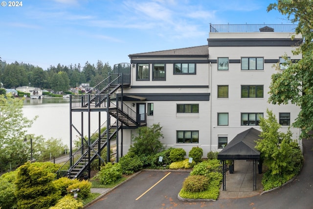 view of building exterior featuring stairs and uncovered parking