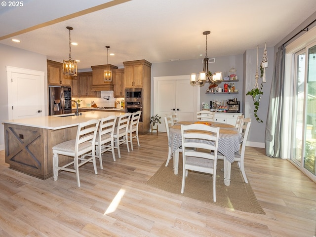 dining space with sink and light wood-type flooring