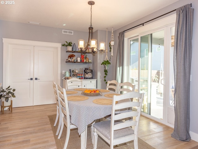 dining area with an inviting chandelier and light wood-type flooring