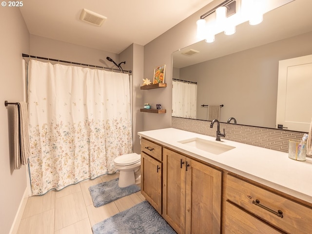 bathroom featuring tasteful backsplash, vanity, and toilet