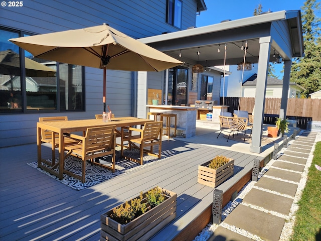 deck featuring ceiling fan and exterior bar