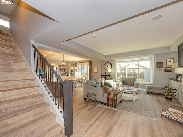 living room with an inviting chandelier and light wood-type flooring