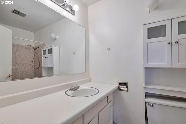 bathroom featuring a shower, vanity, and toilet