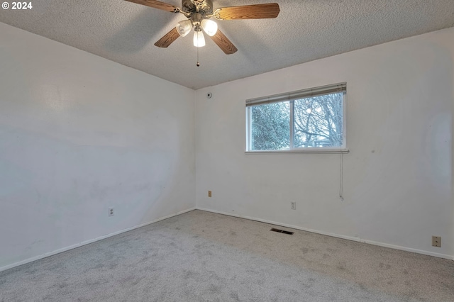 unfurnished room with a textured ceiling, light colored carpet, and ceiling fan