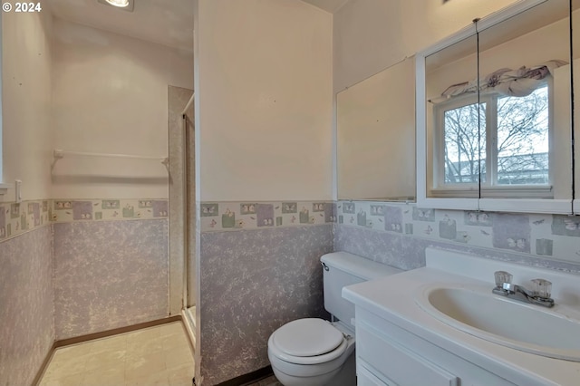 bathroom featuring vanity, toilet, and a shower with shower door