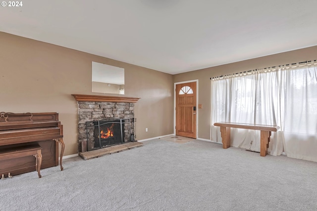 carpeted living room featuring a stone fireplace