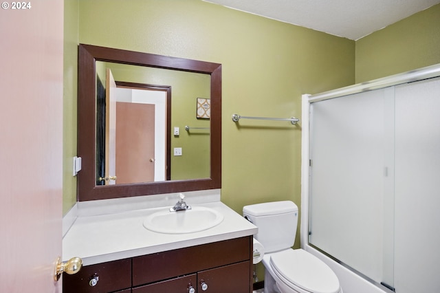 full bathroom featuring vanity, toilet, a textured ceiling, and combined bath / shower with glass door