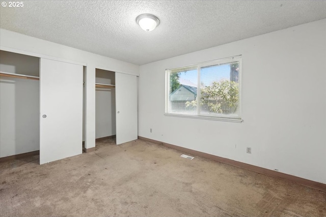 18495 SW Springfield St, Beaverton, OR 97078 - unfurnished bedroom featuring two closets, a textured ceiling, carpet flooring, and baseboards