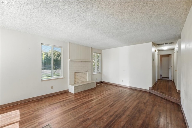18495 SW Springfield St, Beaverton, OR 97078 - unfurnished living room with wood finished floors, healthy amount of natural light, a textured ceiling, a fireplace, and baseboards