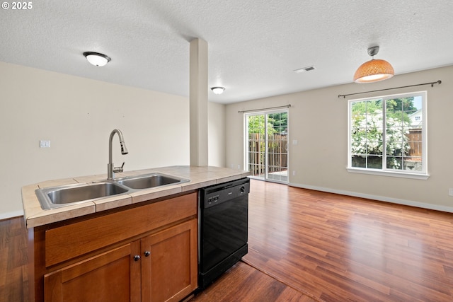 834 NW 3rd Ave, Canby, OR 97013 - kitchen with dishwasher, wood finished floors, brown cabinets, a textured ceiling, and light countertops
