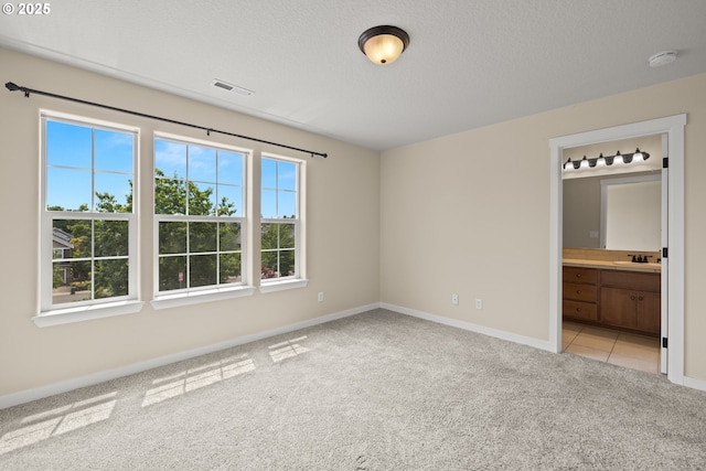 834 NW 3rd Ave, Canby, OR 97013 - unfurnished bedroom featuring light colored carpet, connected bathroom, and a textured ceiling
