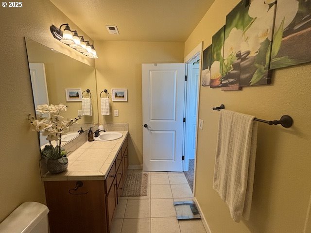 834 NW 3rd Ave, Canby, OR 97013 - bathroom with vanity, tile patterned flooring, toilet, and baseboards