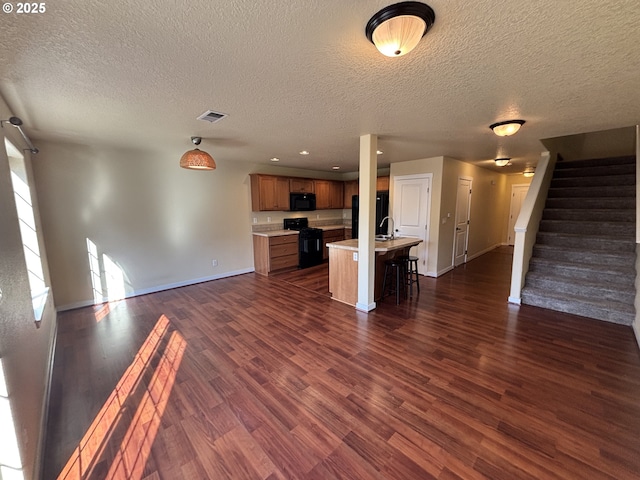 834 NW 3rd Ave, Canby, OR 97013 - unfurnished living room with baseboards, dark wood finished floors, stairway, a textured ceiling, and recessed lighting