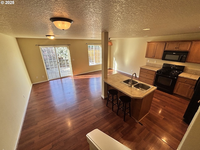 834 NW 3rd Ave, Canby, OR 97013 - kitchen with black appliances, a sink, dark wood finished floors, light countertops, and baseboards