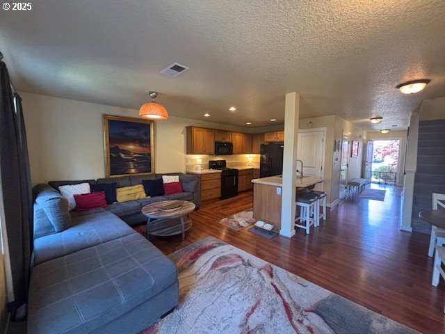 834 NW 3rd Ave, Canby, OR 97013 - living room featuring dark wood-type flooring, a textured ceiling, and recessed lighting