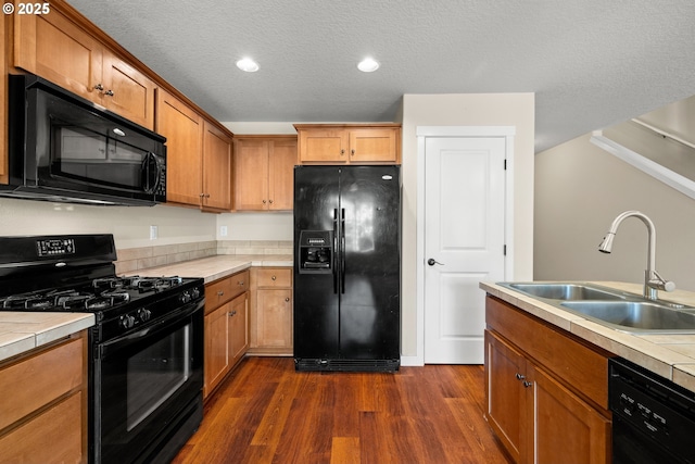 834 NW 3rd Ave, Canby, OR 97013 - kitchen with black appliances, dark wood-style flooring, tile counters, a textured ceiling, and brown cabinetry