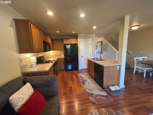 834 NW 3rd Ave, Canby, OR 97013 - kitchen featuring black appliances, a sink, light countertops, open floor plan, and dark wood-style floors