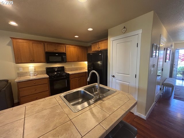 834 NW 3rd Ave, Canby, OR 97013 - kitchen featuring black appliances, a sink, tile counters, dark wood finished floors, and recessed lighting