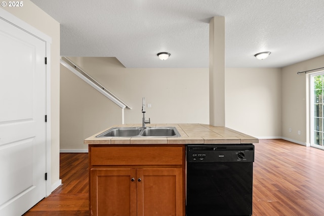 834 NW 3rd Ave, Canby, OR 97013 - kitchen featuring dishwasher, wood finished floors, brown cabinets, a textured ceiling, and tile counters