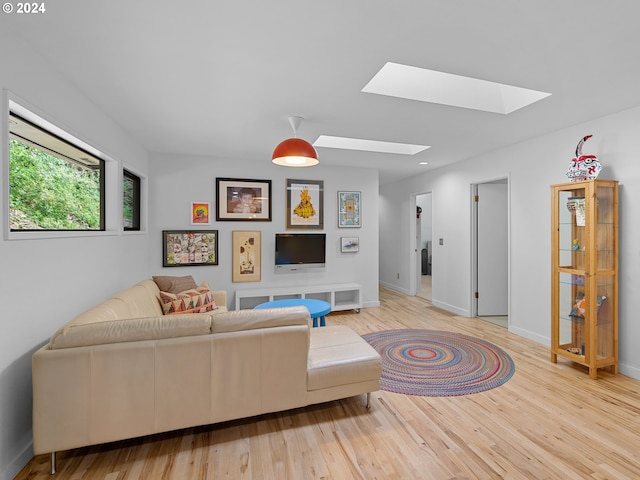 living room featuring a skylight and hardwood / wood-style floors