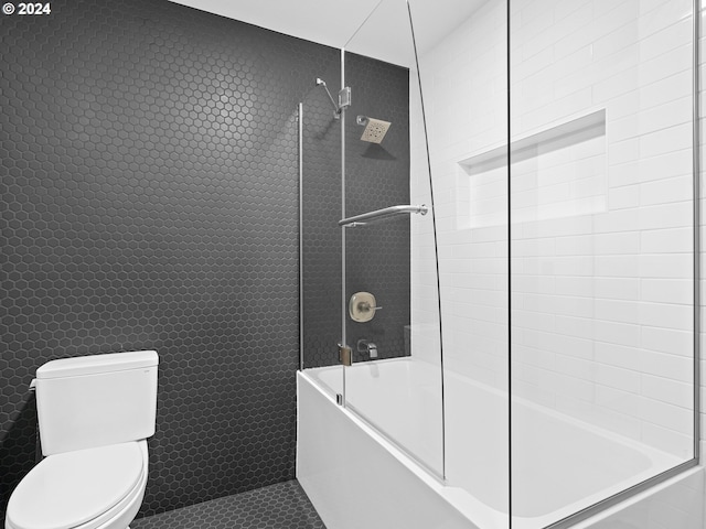 bathroom with combined bath / shower with glass door, toilet, and tile patterned floors