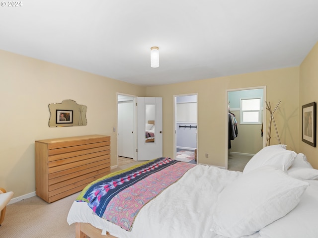 carpeted bedroom featuring a walk in closet and a closet