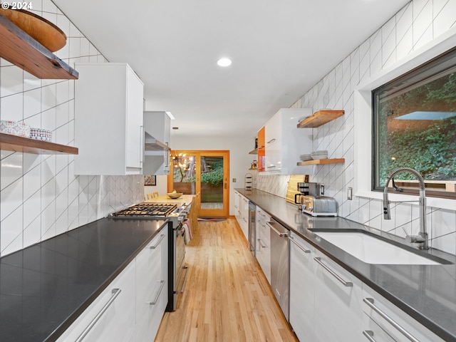 kitchen with appliances with stainless steel finishes, light hardwood / wood-style floors, and white cabinetry