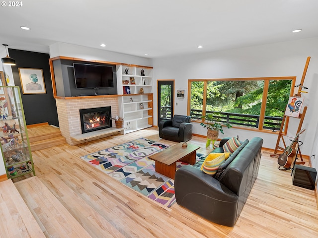 living room with a brick fireplace and light hardwood / wood-style flooring