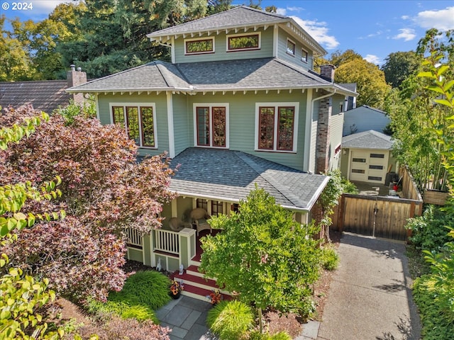 view of front of home featuring a shingled roof, a chimney, and fence