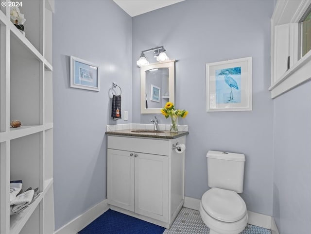 bathroom featuring tile patterned flooring, toilet, and vanity