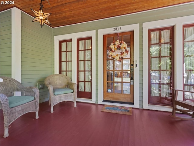 doorway with wood walls, wood-type flooring, and wooden ceiling