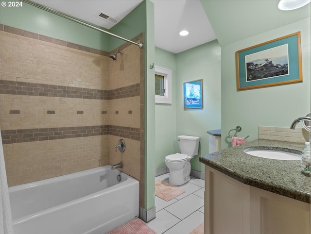 full bathroom with tile patterned flooring, toilet, tiled shower / bath, and vanity