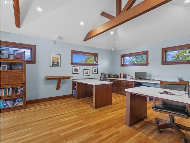 office area with a healthy amount of sunlight, light wood-type flooring, and vaulted ceiling with beams