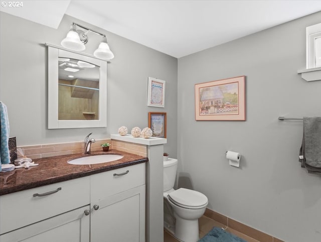 bathroom featuring vanity, toilet, walk in shower, and tile patterned flooring