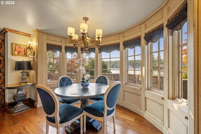 dining room with light hardwood / wood-style flooring, ornamental molding, and an inviting chandelier