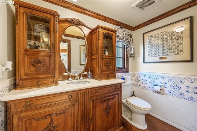 bathroom with ornamental molding, vanity, hardwood / wood-style floors, and toilet