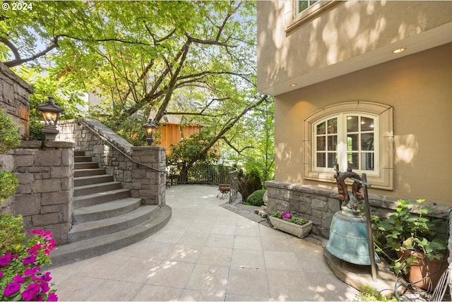 view of patio / terrace featuring stairs and fence