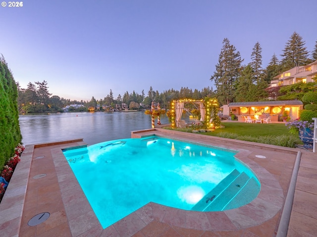 pool at dusk featuring a lawn and a water view