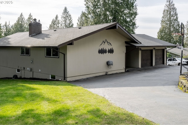 view of home's exterior featuring a garage, a yard, driveway, and a chimney