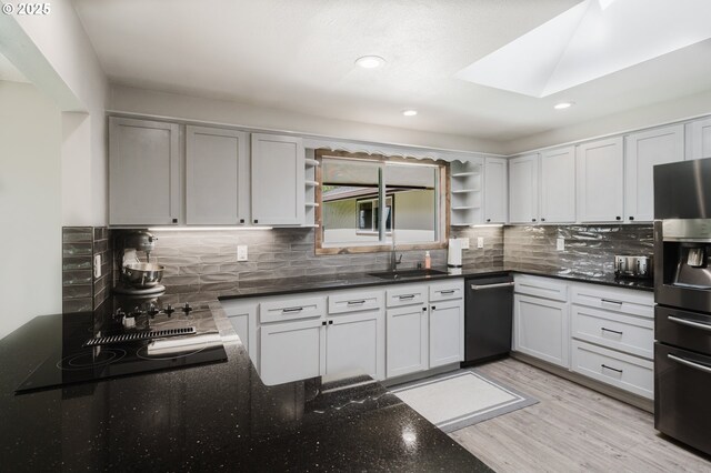 kitchen with backsplash, black microwave, stainless steel oven, and white cabinets