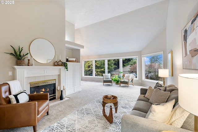 carpeted living room featuring a tiled fireplace, high vaulted ceiling, and a healthy amount of sunlight