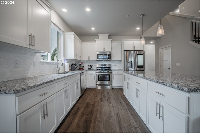 kitchen featuring decorative light fixtures, appliances with stainless steel finishes, dark wood-type flooring, sink, and white cabinets