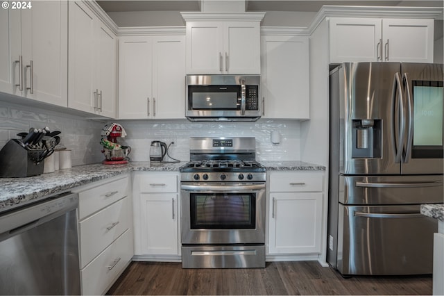 kitchen with dark wood-type flooring, white cabinets, and appliances with stainless steel finishes