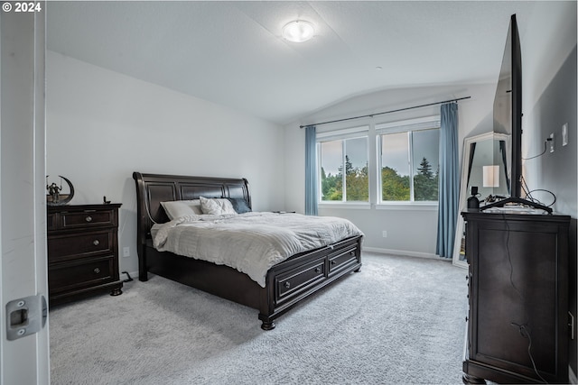 carpeted bedroom with lofted ceiling