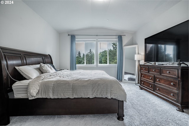 bedroom featuring light colored carpet and vaulted ceiling