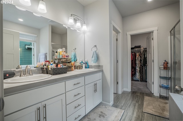 bathroom featuring vanity, a shower with shower door, and wood-type flooring