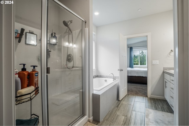 bathroom with vanity, hardwood / wood-style floors, and independent shower and bath