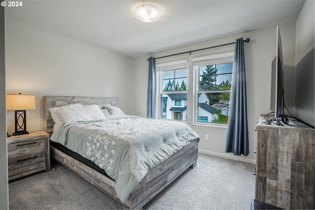 bedroom featuring a textured ceiling and carpet floors