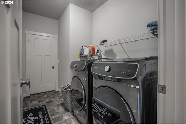 clothes washing area with a textured ceiling and washing machine and clothes dryer