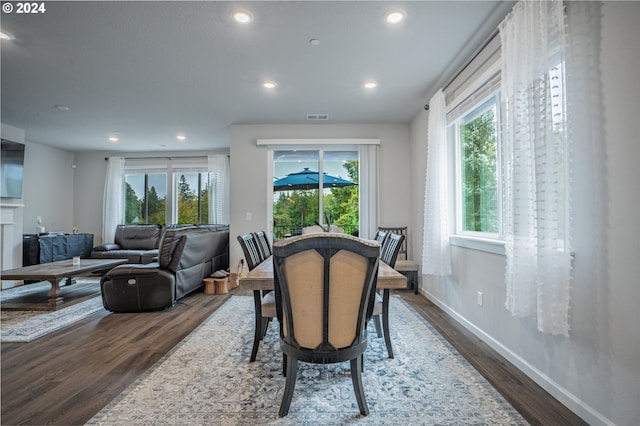 dining area with a wealth of natural light and dark hardwood / wood-style flooring